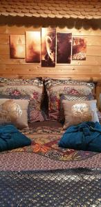 a bed with pillows on it in a room at Aux murmures de la nature in Honfleur