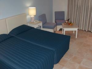 1 Schlafzimmer mit einem Bett, 2 Stühlen und einem Tisch in der Unterkunft Dionysos Central in Paphos City