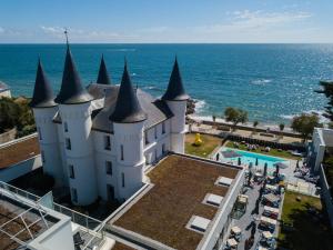 an aerial view of a castle by the ocean at H&ocirc;tel Ch&acirc;teau des Tourelles, Thalasso et piscine d'eau de mer chauff&eacute;e in Pornichet