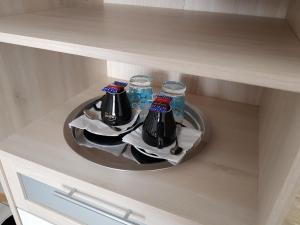 a tray with three drinks on a plate in a cabinet at Hôtel L'ideal le Mountbatten in Arromanches-les-Bains