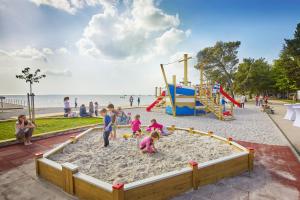 a group of children playing in the sand at the beach at Villa Bor - Hotel & Resort Adria Ankaran in Ankaran