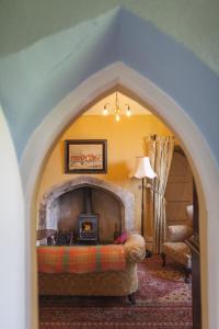 a living room with a fireplace and a couch at Anne's Grove Miniature Castle in Castletownroche