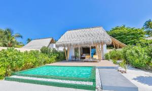 a villa with a swimming pool and a house at Emerald Maldives Resort & Spa-Deluxe All Inclusive in Raa Atoll