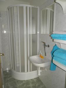 a bathroom with a sink and a shower with blue towels at Holiday House Smetánek in Bruntál +40 photos