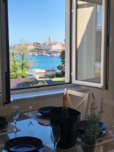 a table with glasses and a view of a window at Citypark Apartment in Rab