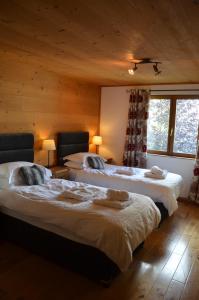 a room with two beds in a log cabin at Chalet Morville in Vénosc