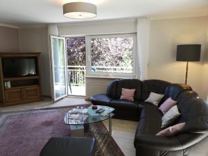 uma sala de estar com um sofá e uma televisão em Appart-Pension-Schier em Zell an der Mosel