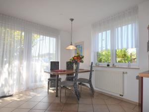 a dining room with a table and chairs and windows at Peaceful Holiday Home in Dranske on an Island in Hof Dranske