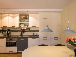 a kitchen with white cabinets and a table at Beautiful holiday home near the forest in Carsac-Aillac