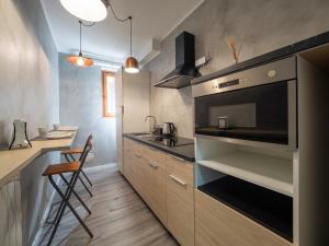 een keuken met een wastafel en een fornuis top oven bij IL RICCIO Rooms in Milaan