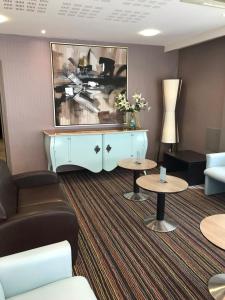 a living room with a couch and a table at Helgon Hotel - Lourdes Pyrénées in Lourdes