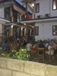 a group of people sitting outside of a restaurant at Bima Homestay Lembongan in Nusa Lembongan