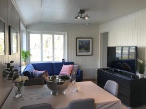a living room with a table and a blue couch at Nyksund Appartement, Nyksund Brygge in Nyksund