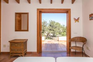 a bedroom with a door leading to a patio at Sa Voliaina in La Savina