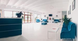a living room with blue chairs and a table at Hotel Carmen in Venus