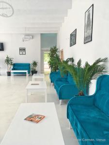 a living room with blue couches and a table at Hotel Carmen in Venus