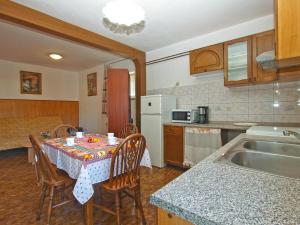 - une cuisine avec une table, des chaises et un évier dans l'établissement Apartments Marija 841, à Pula