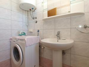 La salle de bains est pourvue d'un lavabo et d'un lave-linge. dans l'établissement Apartments Marija 841, à Pula