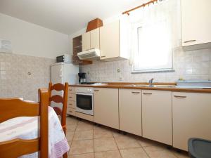 La cuisine est équipée de placards blancs et d'un réfrigérateur blanc. dans l'établissement Apartments Marija 841, à Pula