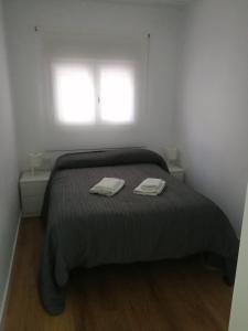 a bedroom with a bed with two towels on it at Piso nuevo en pleno centro de Cadiz, calle Plocia in Cádiz