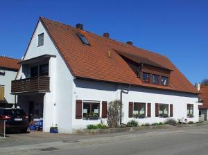 uma casa branca com um telhado vermelho em Die Galerie - Ferienwohnung em Merkendorf