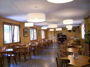 a restaurant with wooden tables and chairs and lights at Hotel Prats in Ribes de Freser