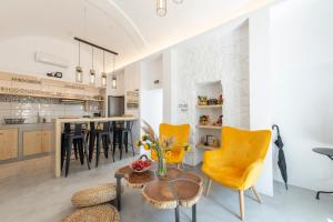 una cucina e un soggiorno con sedie gialle e tavolo di Bedspot Hostel a Firà Altre 37 foto