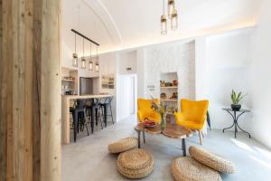 un soggiorno con tavolo e sedie gialle di Bedspot Hostel a Firà
