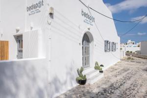 a small white building with a blue wall at Bedspot Hostel in Fira