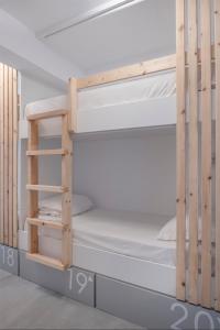 a wooden bunk bed in a small room at Bedspot Hostel in Fira