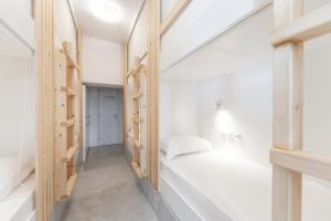 una stanza con pareti bianche e scaffali in legno di Bedspot Hostel a Firà