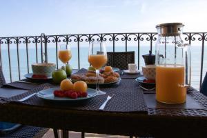 una mesa con platos de comida y vasos de zumo de naranja en Sea You Apartamentos Valencia Port Saplaya, en Port Saplaya