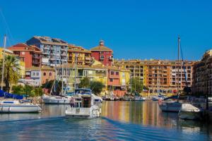 a group of boats docked in a harbor with buildings at Sea You Apartamentos Valencia Port Saplaya in Port Saplaya