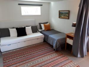 1 dormitorio con 2 camas, ventana y alfombra en Stuga Bra Nock, en Brösarp