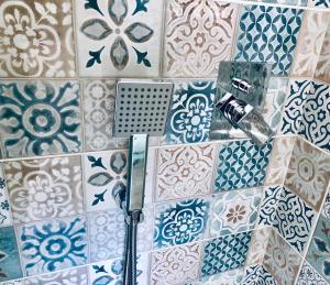 a bathroom with blue and white tiles on a wall at Casa Maccers in Giardini Naxos +24 photos