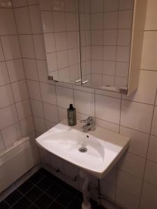 ein Badezimmer mit einem weißen Waschbecken und einem Spiegel in der Unterkunft Stuga Bra Nock in Brösarp