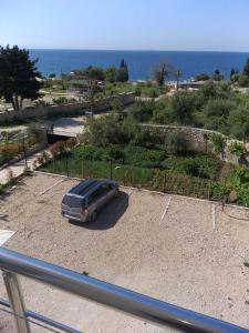 a van parked in a parking lot next to the ocean at Hotel Afrodite in Dhërmi