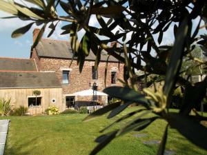 Saint-Malon-sur-Mel的住宿－Il était une fois Brocéliande，一座带草地庭院的大型砖砌建筑