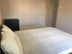 a small bedroom with a bed and a dresser at Anyksciu liuksas in Anykščiai