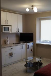 a kitchen with white cabinets and a table and a window at Anyksciu liuksas in Anykščiai +2 photos