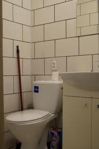La salle de bains est pourvue de toilettes blanches et d'une cafetière à piston rouge. dans l'établissement Anyksciu liuksas, à Anykščiai