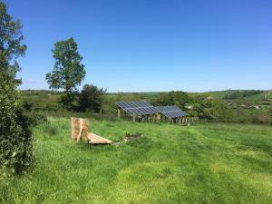 um grupo de painéis solares num campo em Rivendell Glamping Pods em Holsworthy