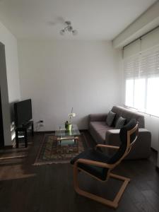 a living room with a couch and a chair at B&B Stadio Apartment in Pordenone