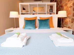 1 dormitorio con 1 cama con almohadas azules y naranjas en Braga Bells Guesthouse, en Braga