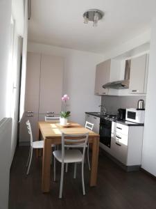 a small kitchen with a wooden table and chairs at B&B Stadio Apartment in Pordenone