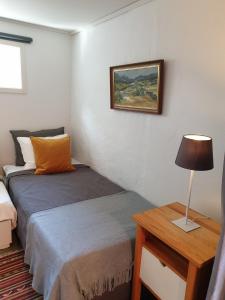 1 dormitorio con 1 cama y 1 mesa con lámpara en Stuga Bra Nock, en Brösarp
