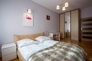 a bedroom with a bed with a bird picture on the wall at Grand Apartments - Deluxe Apartment with Balcony in Gdańsk