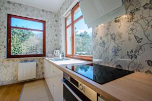 a kitchen with a sink and a window at Grand Apartments - Deluxe Apartment with Balcony in Gdańsk