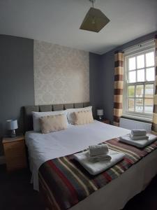 a bedroom with a large bed with two towels on it at The Lowman in Tiverton