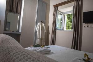 sypialnia z łóżkiem, lustrem i oknem w obiekcie Kyria Boutique House w Atenach